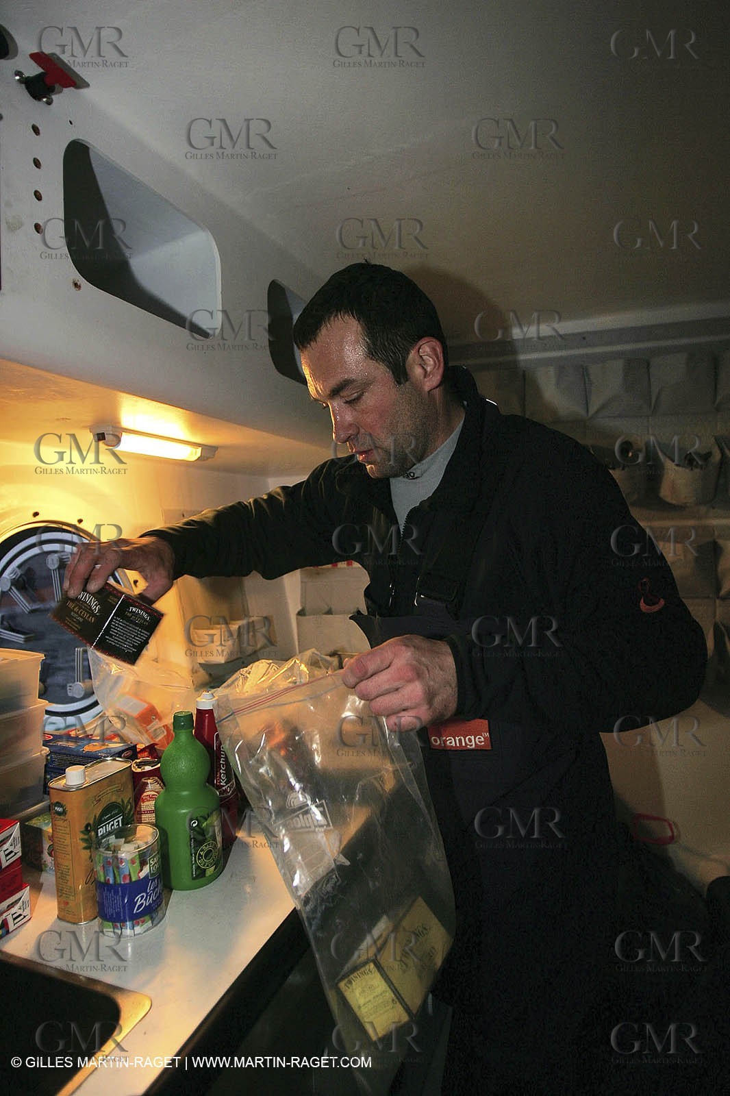 Orange II - Jules Verne Trophy 2004 - Jean-Baptiste Epron preparing food in the galley
